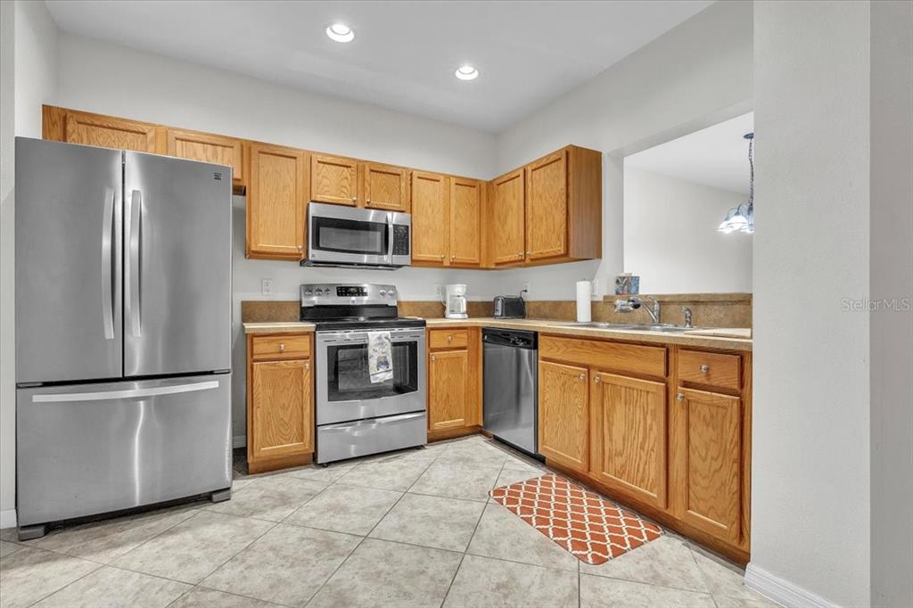 3954 Cherrybrook Loop Fort Myers, FL 33966 - Photo 16 of 47 a kitchen with granite countertop a refrigerator stove top oven and sink