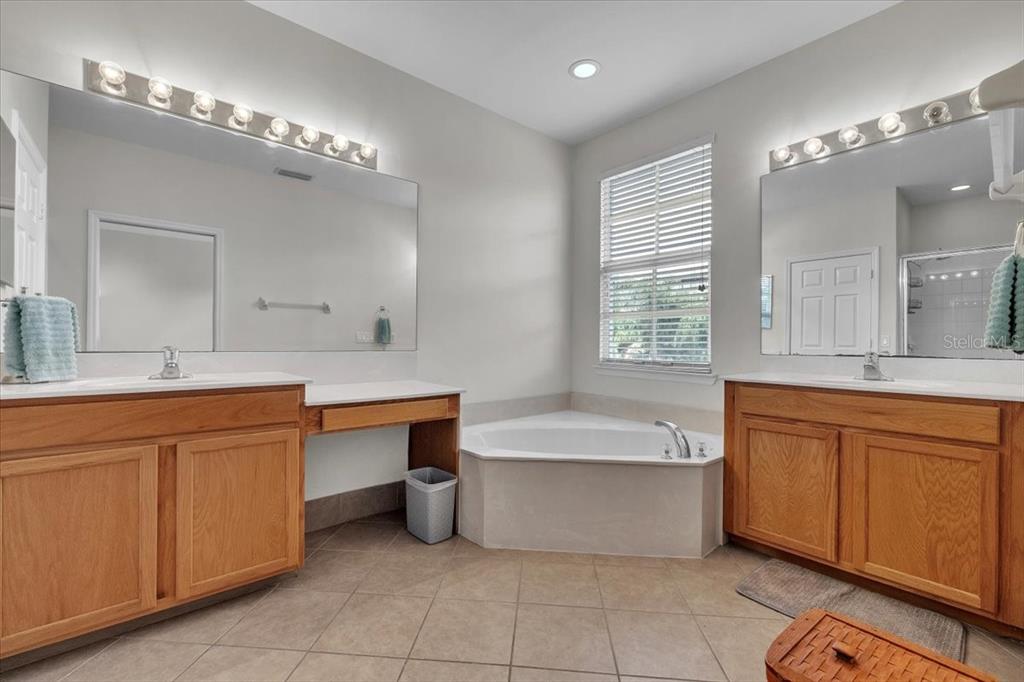 3954 Cherrybrook Loop Fort Myers, FL 33966 - Photo 26 of 47 a spacious bathroom with a granite countertop double vanity sink mirror bathtub and window