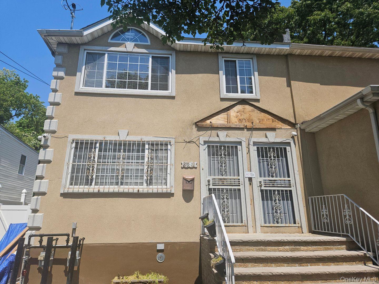 219-19 143rd Road Queens, NY 11413 - Photo 1 of 4 a front view of a house with a porch