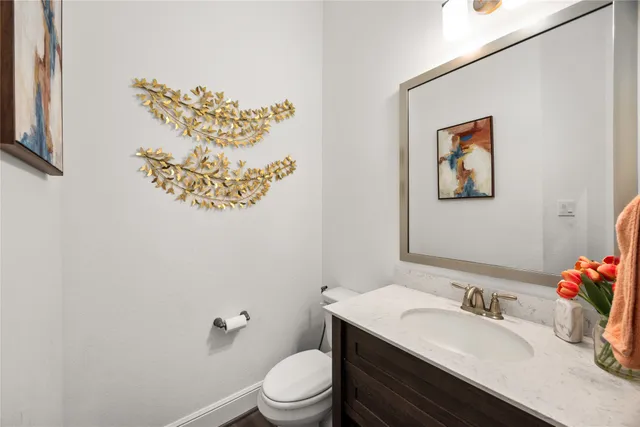 a bathroom with a sink mirror vanity and toilet