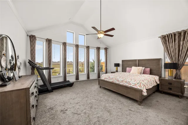 a spacious bedroom with a bed a flat screen tv and a large window