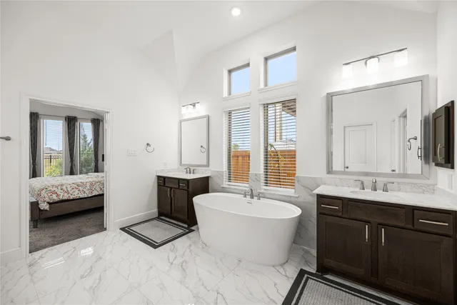 a spacious bathroom with a double vanity sink double mirror and bathtub