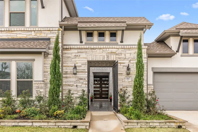 a view of a white house with potted plants