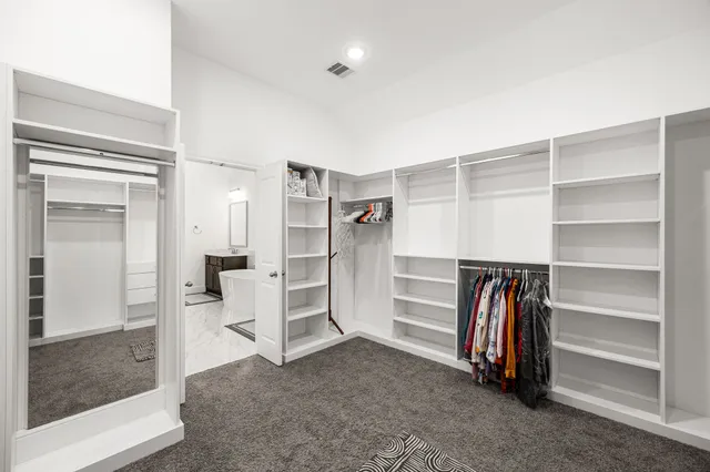 a view of walk in closet with empty racks