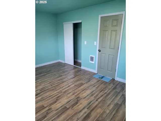 a view of a room with wooden floor