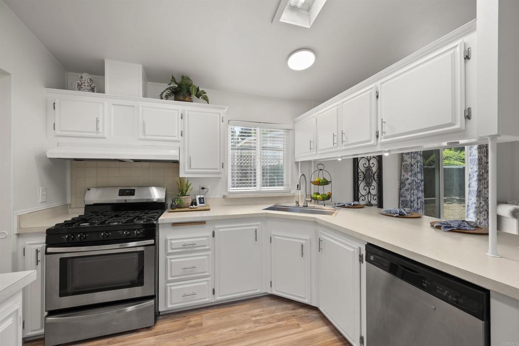 8620 Atlas View Drive Santee, CA 92071 - Photo 27 of 58 a kitchen with granite countertop white cabinets stainless steel appliances and a window