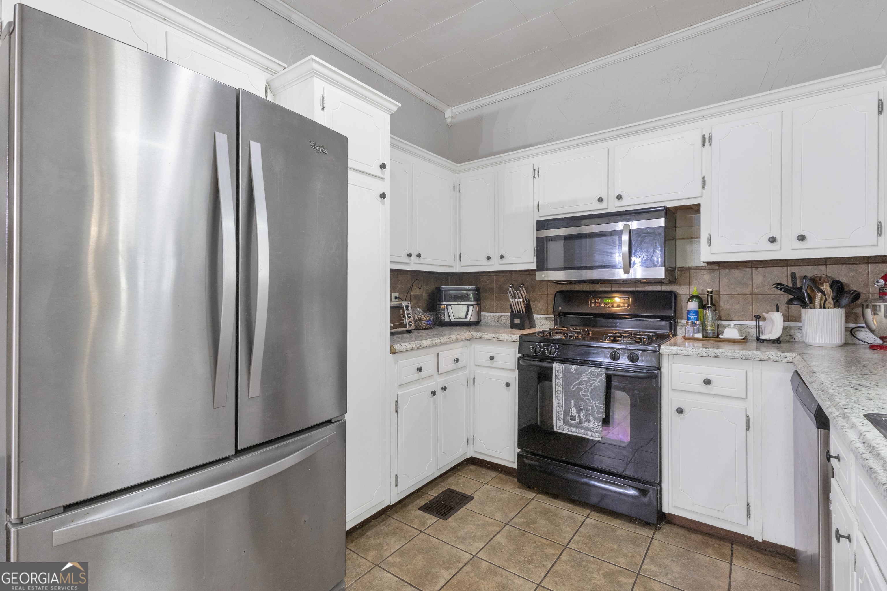 32 Post Street Grantville, GA 30220 - Photo 22 of 39 a kitchen with stainless steel appliances a refrigerator sink and white cabinets