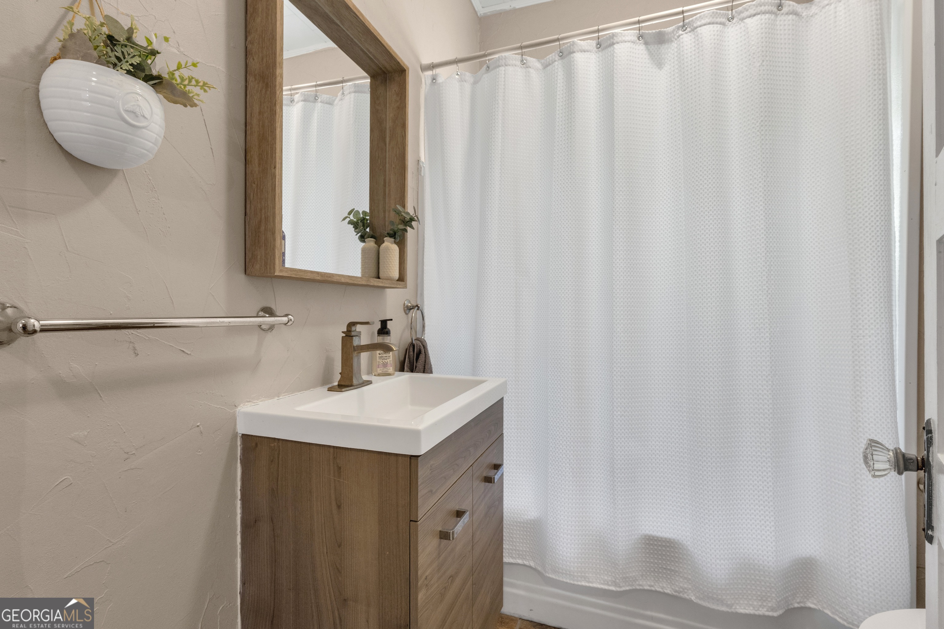 32 Post Street Grantville, GA 30220 - Photo 30 of 39 a bathroom with a sink a mirror and a shower curtain