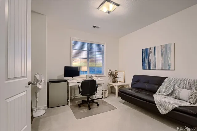 a view of a livingroom with workspace and a couch
