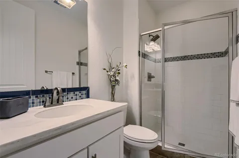 a bathroom with a granite countertop sink toilet and shower