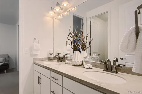 a bathroom with double vanity sinks a vanity and a mirror