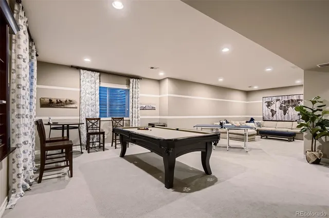 a room with lots of furniture a desk and a pool table