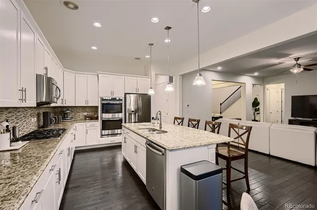 a large kitchen with kitchen island a sink table and chairs