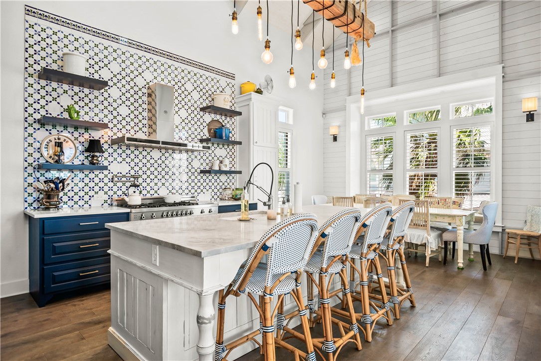 200 Round Road Port Aransas, TX 78373 - Photo 7 of 38 a kitchen with stainless steel appliances granite countertop a dining table chairs and a wooden floor