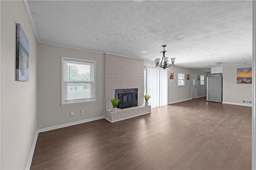5245 Stonewall Tell Road Atlanta, GA 30349 - Photo 6 of 15 a view of a livingroom with a fireplace window and wooden floor