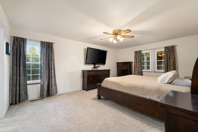a spacious bedroom with a bed and a chandelier