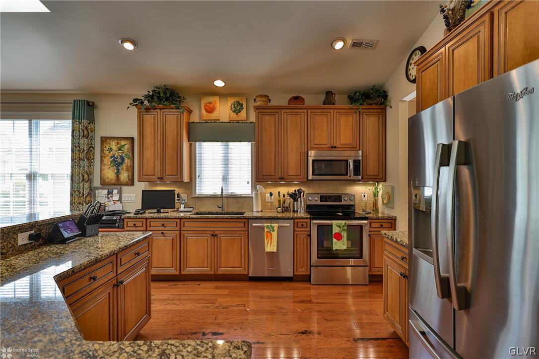1015 Declaration Drive Bethlehem, PA 18017 - Photo 12 of 33 a kitchen with stainless steel appliances granite countertop a stove a sink dishwasher a refrigerator and a microwave