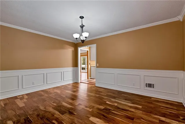 a view of a livingroom with a piano and wooden floor