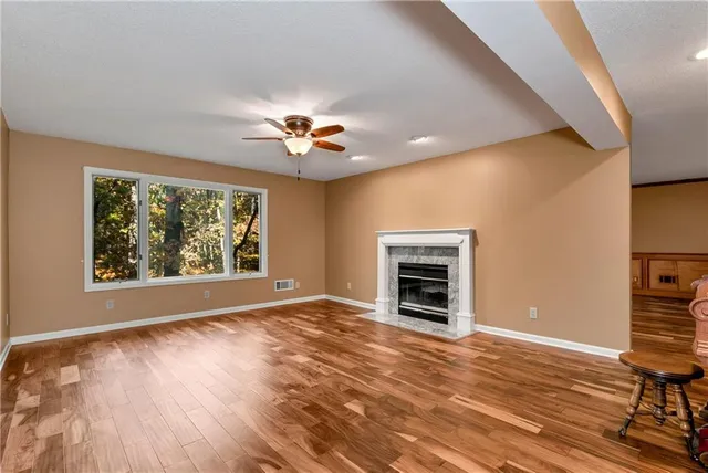 a view of a livingroom with wooden floor and a large window