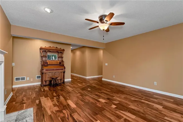 a living room with a fireplace furniture and a ceiling fan
