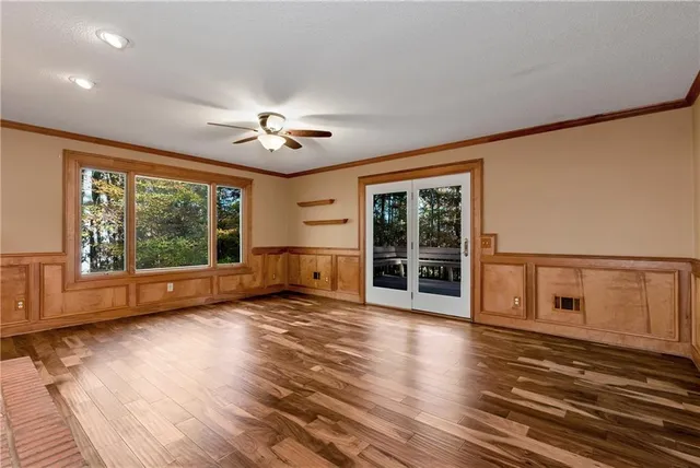a view of empty room with wooden floor