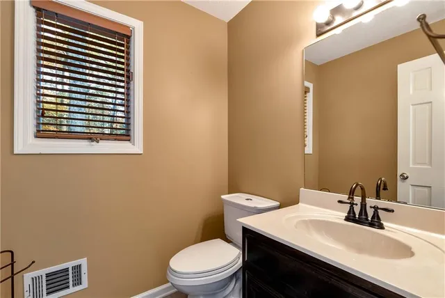 a view of an empty room with window and a ceiling fan