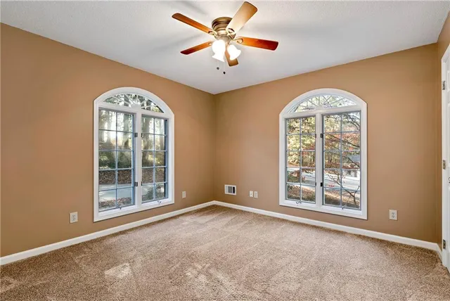 a living room with furniture and a ceiling fan