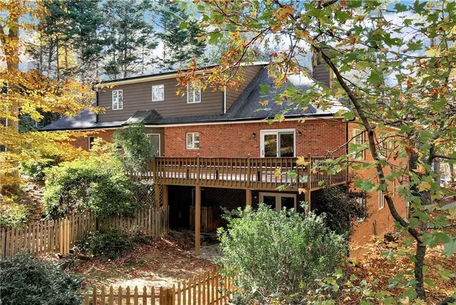 a backyard of a house with deck and outdoor seating