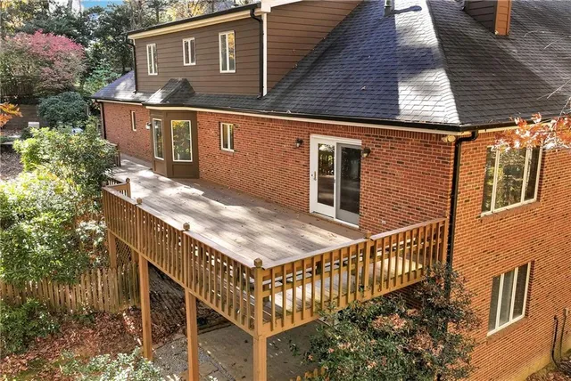 a backyard of a house with large trees and wooden fence