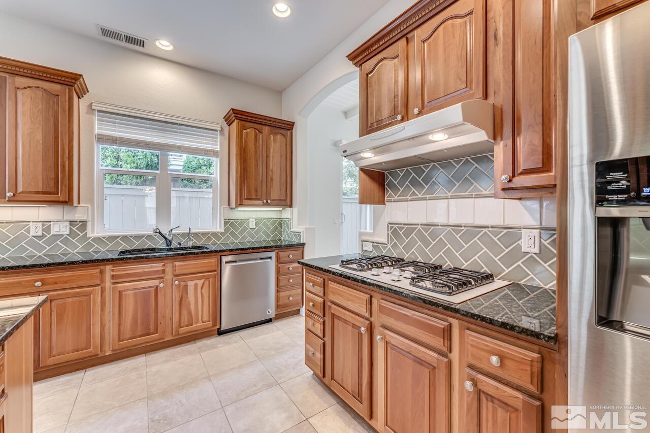7625 Stone Bluff Way Reno, NV 89523 - Photo 13 of 32 a kitchen with stainless steel appliances granite countertop a stove a sink and a microwave