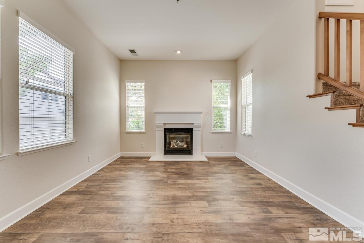 7625 Stone Bluff Way Reno, NV 89523 - Photo 6 of 32 a view of an empty room with wooden floor fireplace and a window
