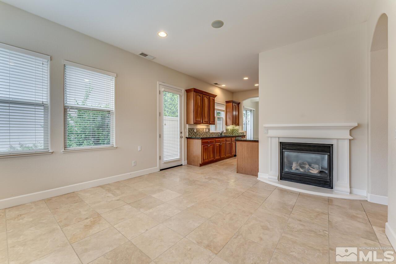 7625 Stone Bluff Way Reno, NV 89523 - Photo 9 of 32 an empty room with kitchen and fireplace
