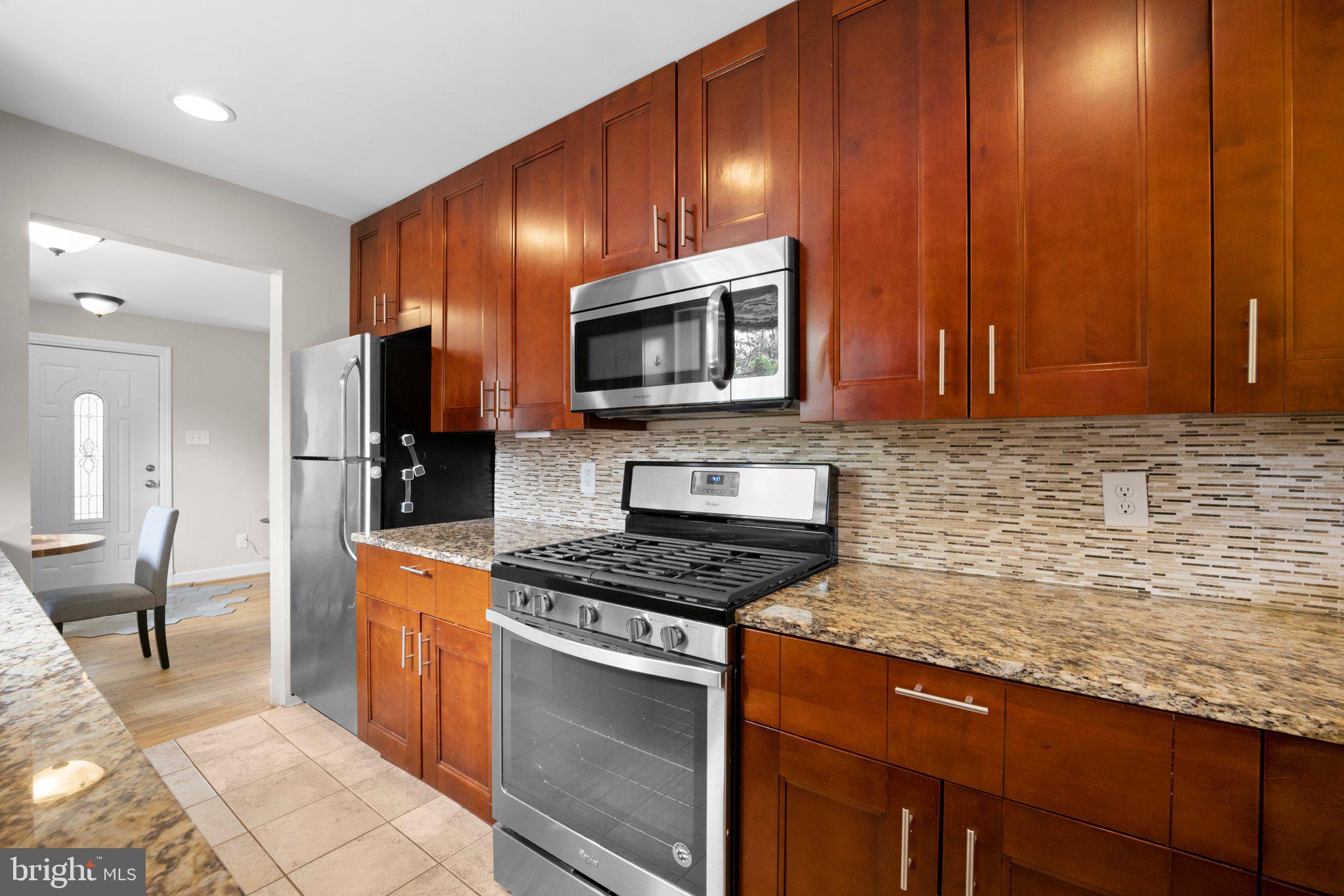 1812 Florin Street Silver Spring, MD 20902 - Photo 11 of 38 a kitchen with stainless steel appliances granite countertop a stove a sink and a microwave