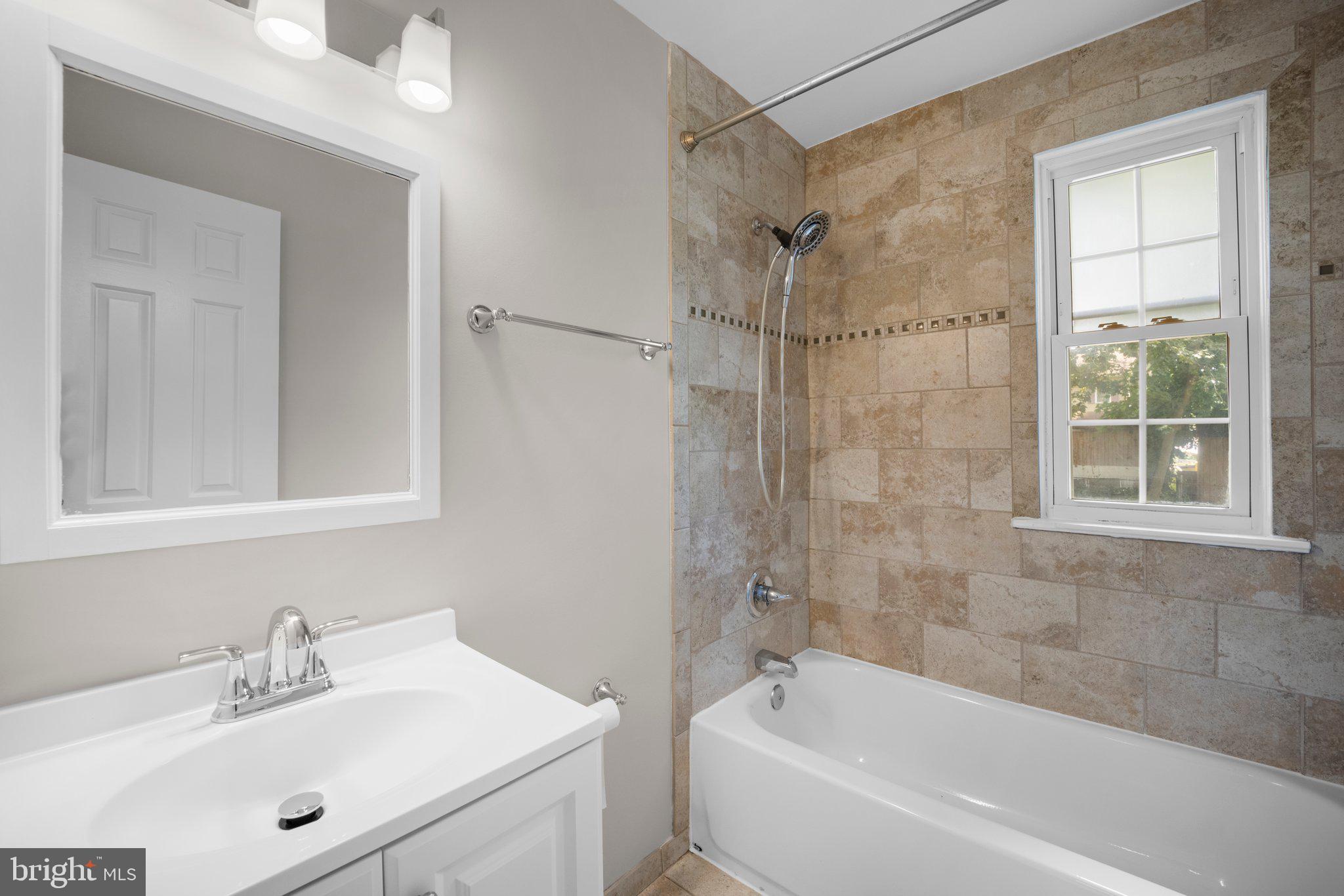 1812 Florin Street Silver Spring, MD 20902 - Photo 15 of 38 a white bath tub sitting next to a white sink and a mirror