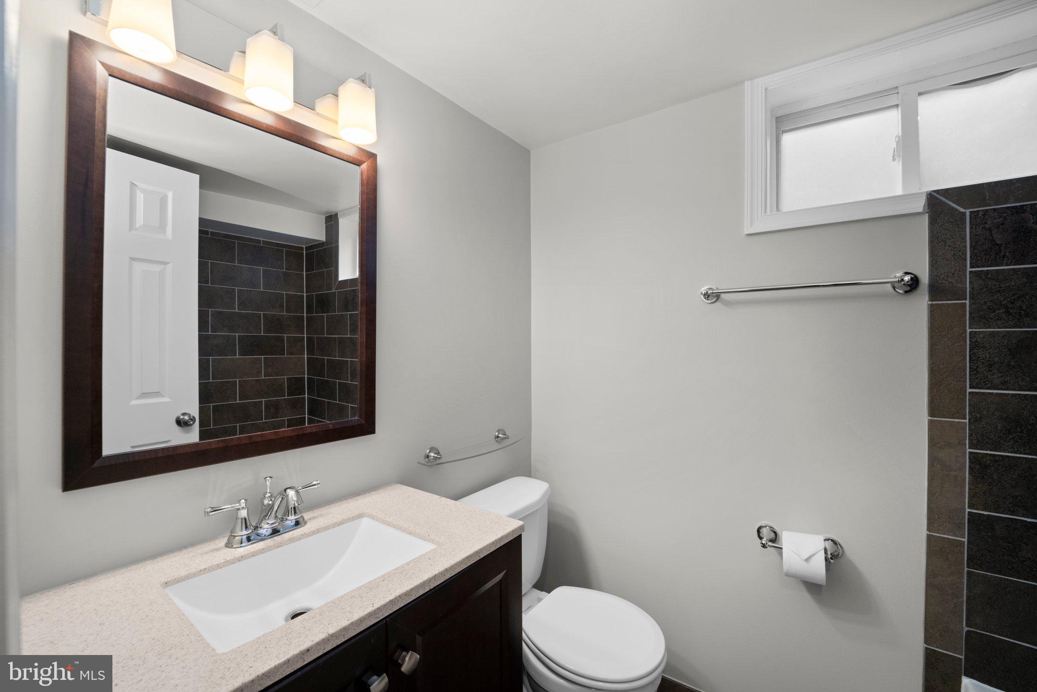 1812 Florin Street Silver Spring, MD 20902 - Photo 31 of 38 a bathroom with a sink vanity mirror and toilet