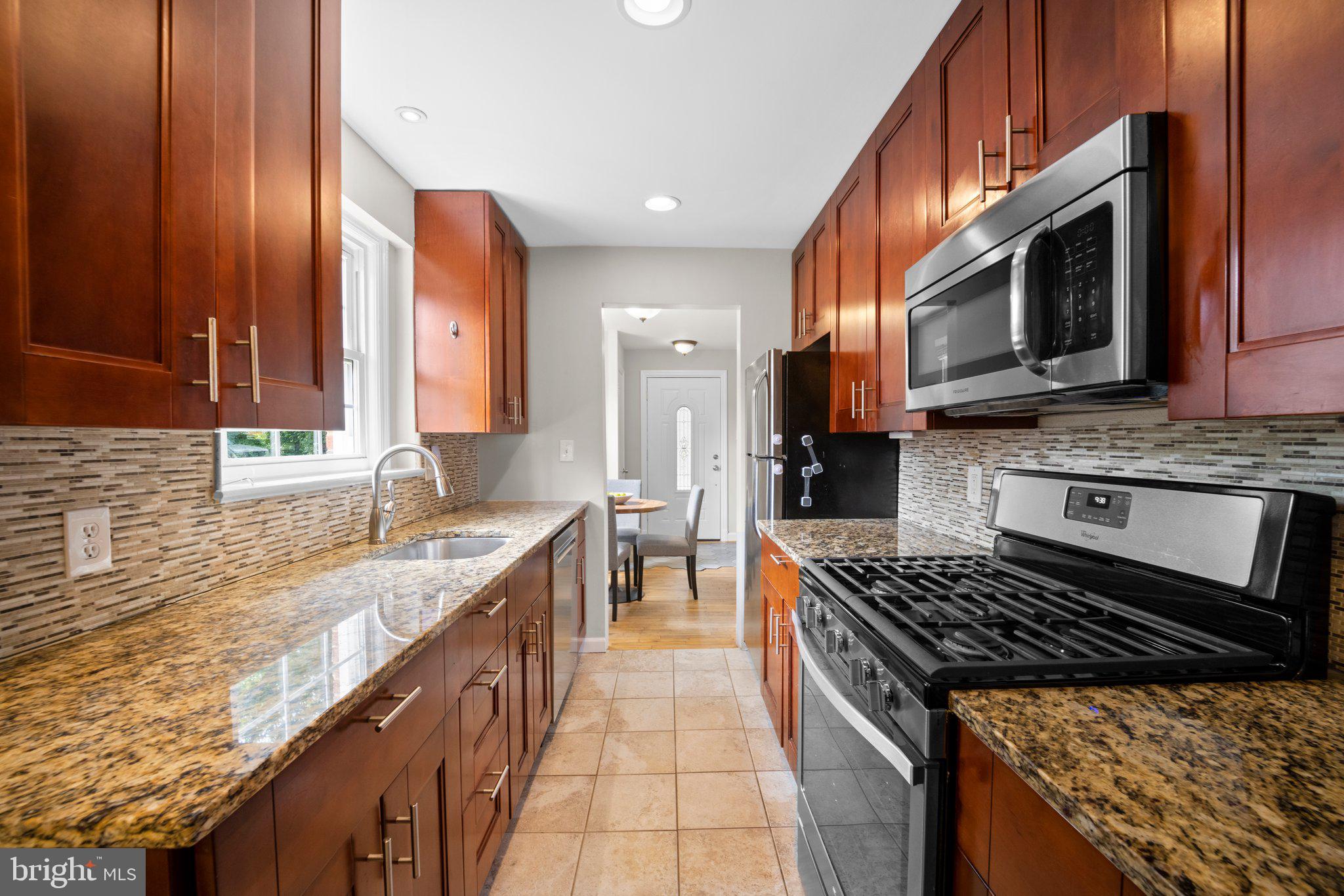 1812 Florin Street Silver Spring, MD 20902 - Photo 10 of 38 a kitchen with stainless steel appliances granite countertop a stove a sink and a microwave