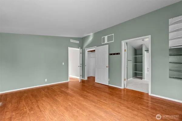 a view of empty room with wooden floor