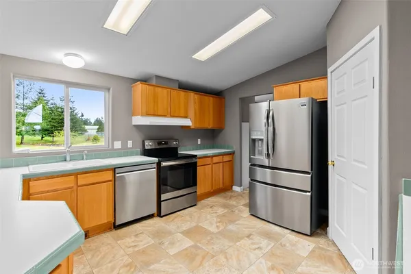 a kitchen with stainless steel appliances granite countertop a refrigerator sink and stove