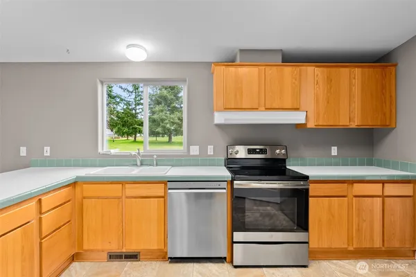 a kitchen with granite countertop a stove a sink and a microwave