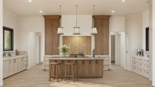 a kitchen with stainless steel appliances kitchen island granite countertop a refrigerator a sink dishwasher and white cabinets with wooden floor