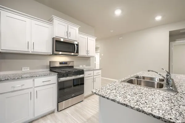 a kitchen with stainless steel appliances granite countertop a sink stove and refrigerator