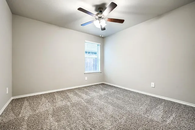 a view of an empty room with wooden floor and a fireplace