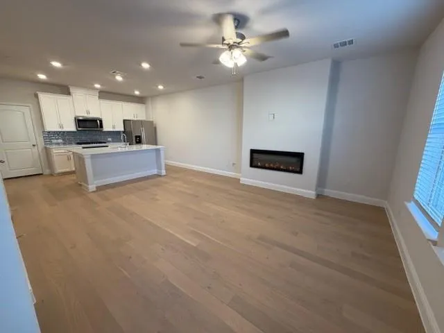 a living room with stainless steel appliances kitchen island furniture and a fireplace