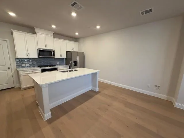 a kitchen with a sink cabinets and wooden floor