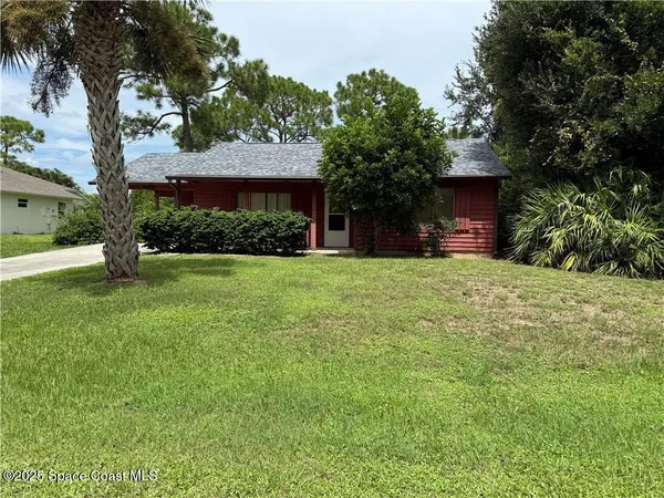 a view of a house with a yard and tree