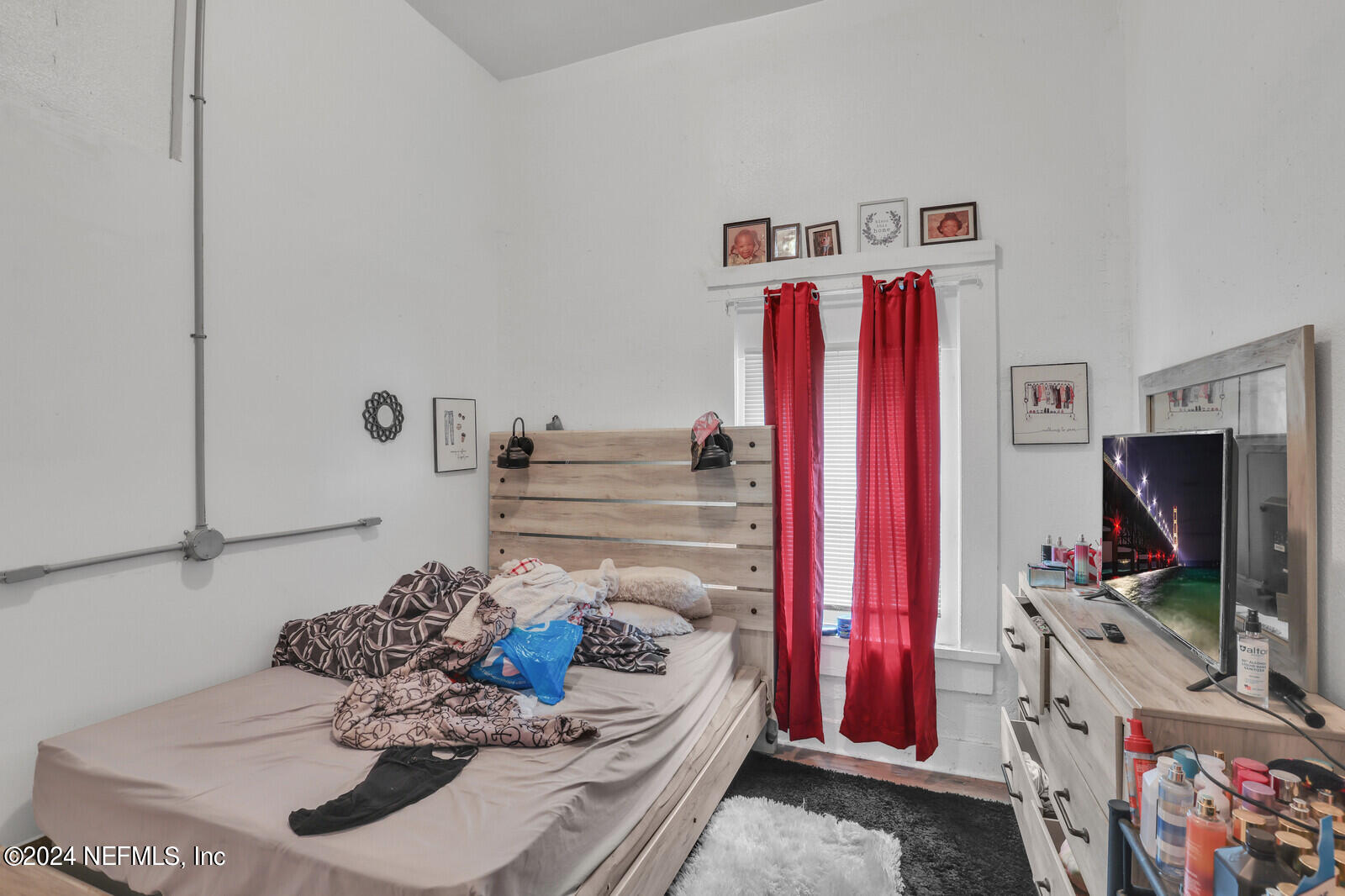 2306 Moncrief Road Jacksonville, FL 32209 - Photo 12 of 14 a bedroom with a bed and a flat screen tv