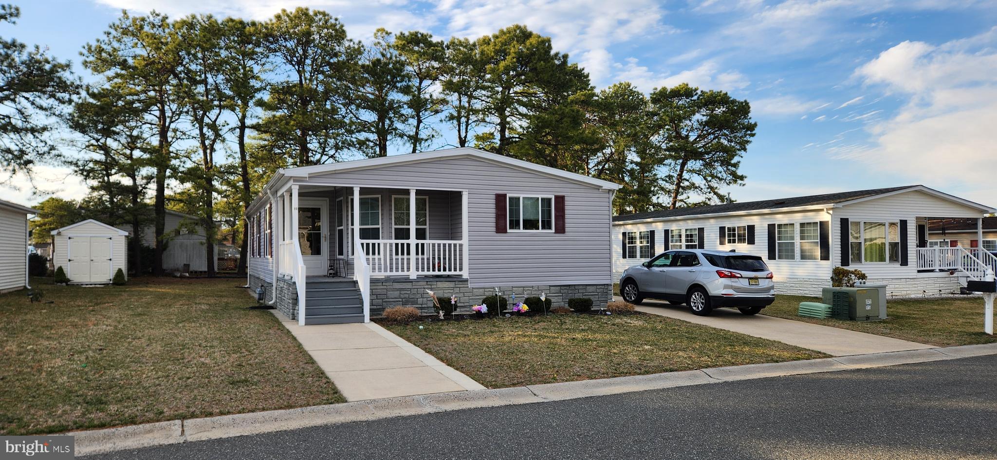 77 Pine Ridge Boulevard Whiting, NJ 08759 - Photo 14 of 49 a front view of a house with a garden and trees