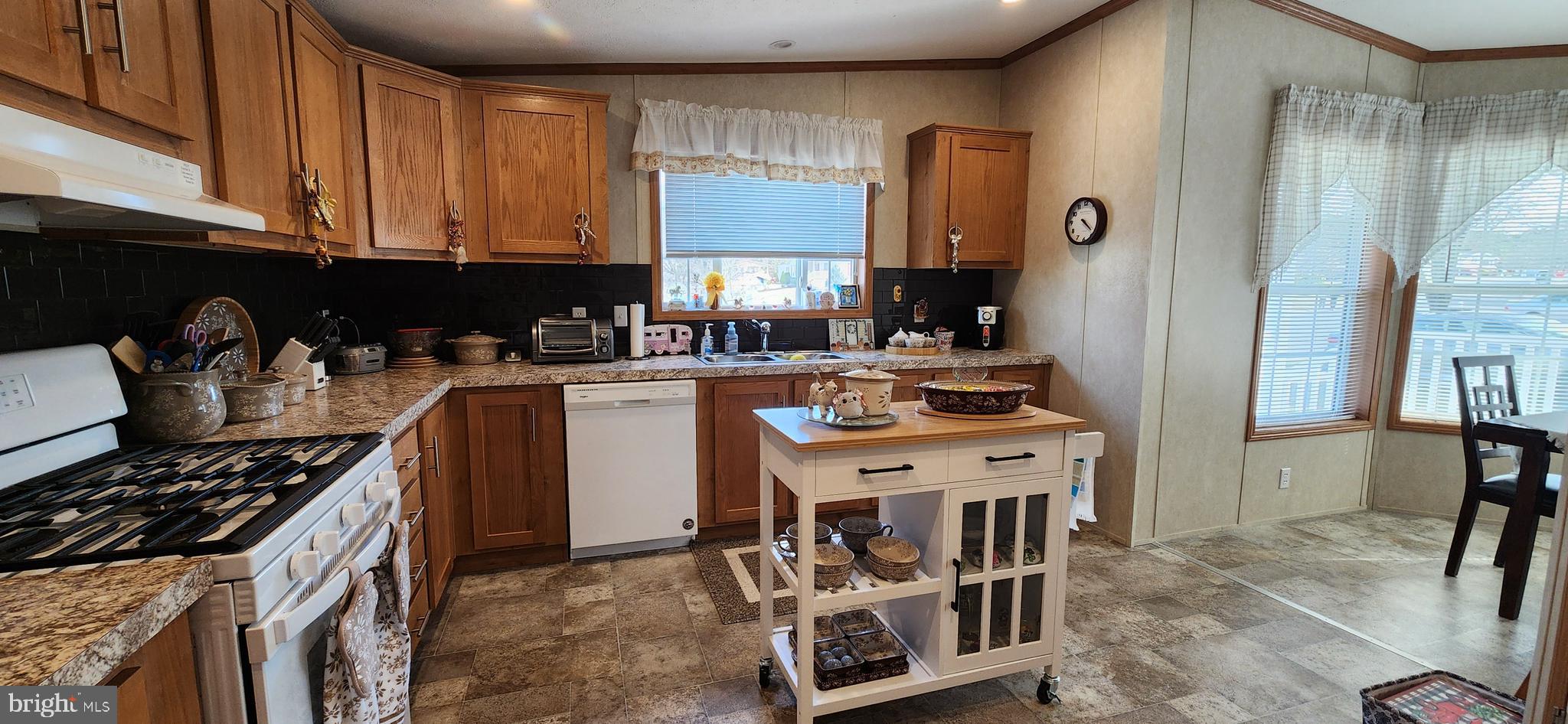 77 Pine Ridge Boulevard Whiting, NJ 08759 - Photo 5 of 49 a kitchen with stainless steel appliances granite countertop a stove top oven a sink a dining table and chairs