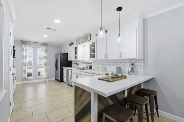 a kitchen with stainless steel appliances granite countertop a sink refrigerator and cabinets