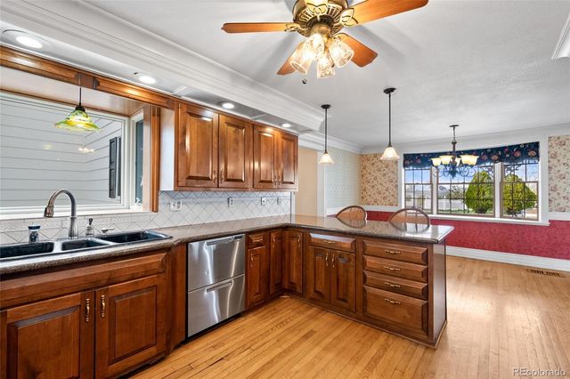 a kitchen with stainless steel appliances a sink a stove and wooden cabinets